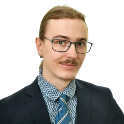 Hymyilevä nuori mies, jolla on puku päällä.