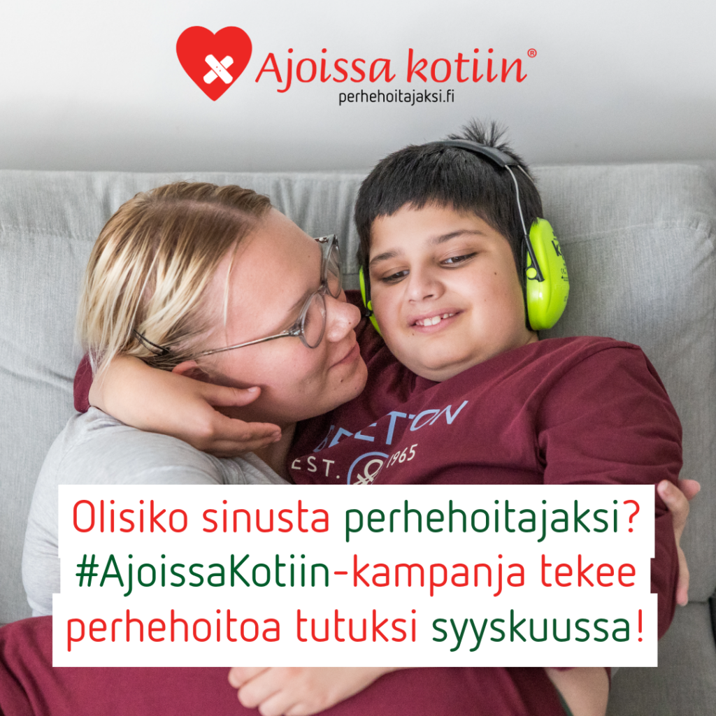 Silmälasipäinen aikuinen ja lapsi, jolla on kuulosuojaimet, halaavat.