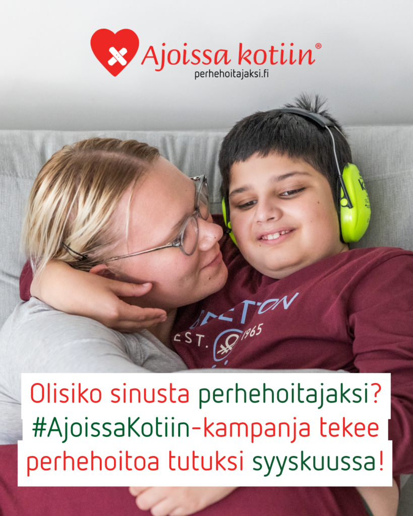 Silmälasipäinen aikuinen ja lapsi, jolla on kuulosuojaimet, halaavat.
