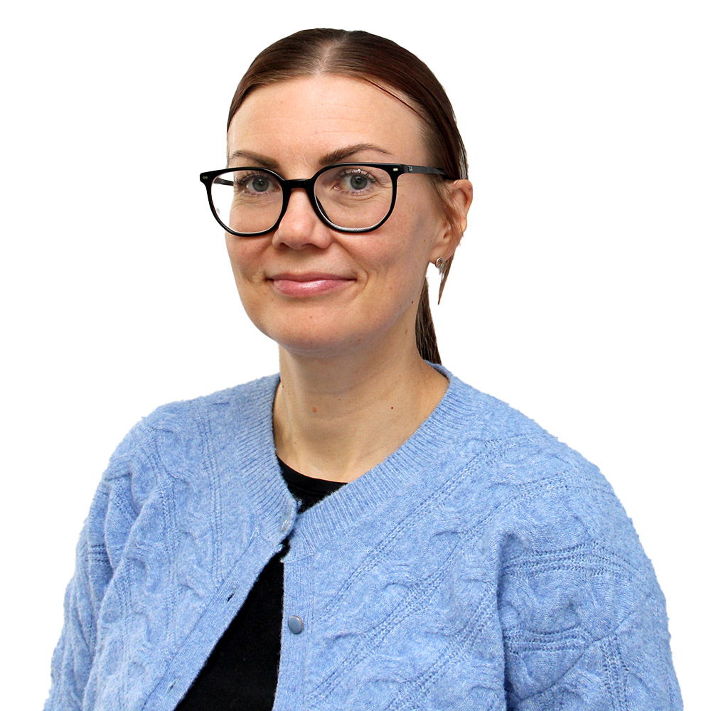 Silmälasipäinen nainen hymyilee.